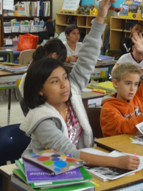 Washington District Elementary students raising their hand to answer a question.